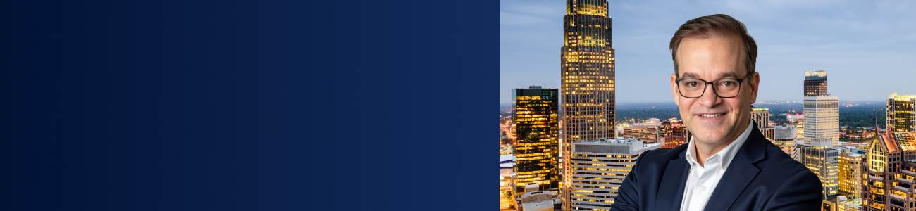 Michael D. Maurer pictured against the Charlotte skyline at dusk.